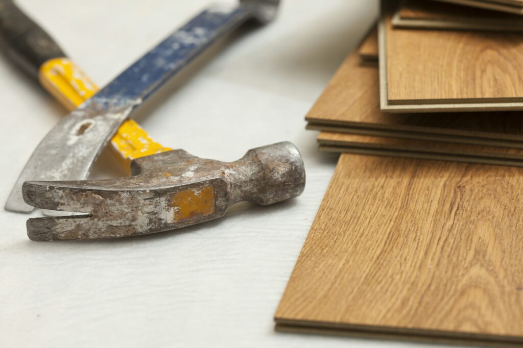 Worn Hammer and Pry Bar with Laminate Flooring Abstract.